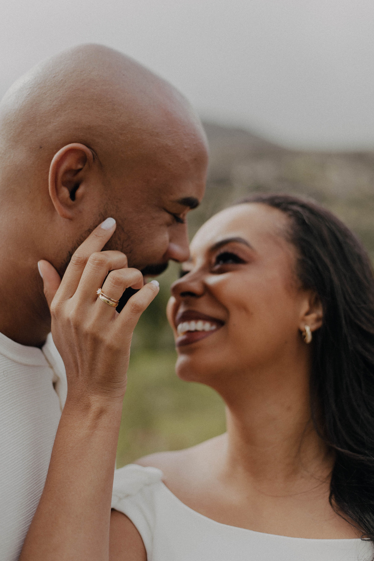 A couple sharing a close, joyful moment, foreheads nearly touching